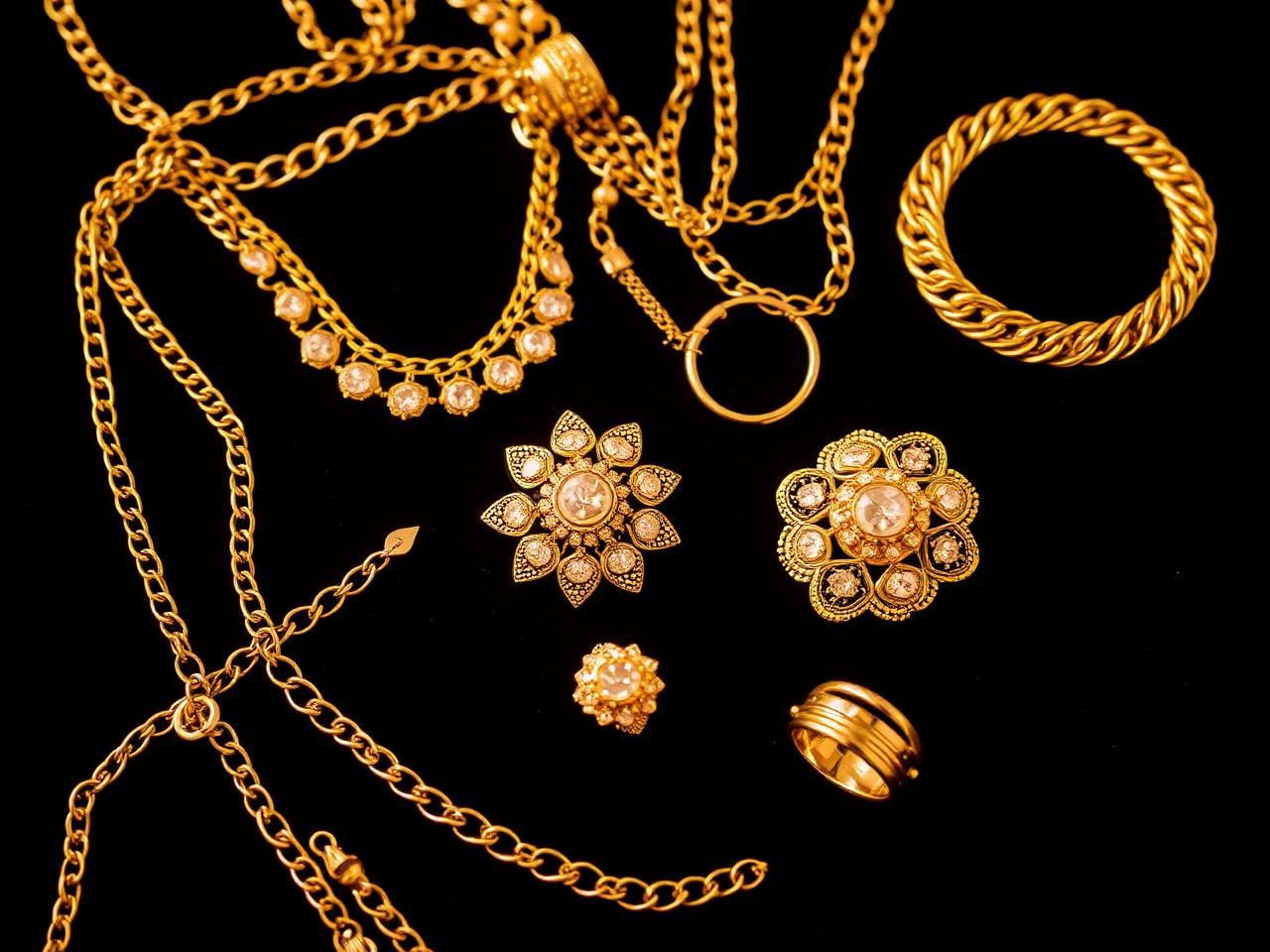 Gouden ringen, schakelketting, munt en goudbaar klaar voor taxatie — goud inkoop Huizen en omgeving